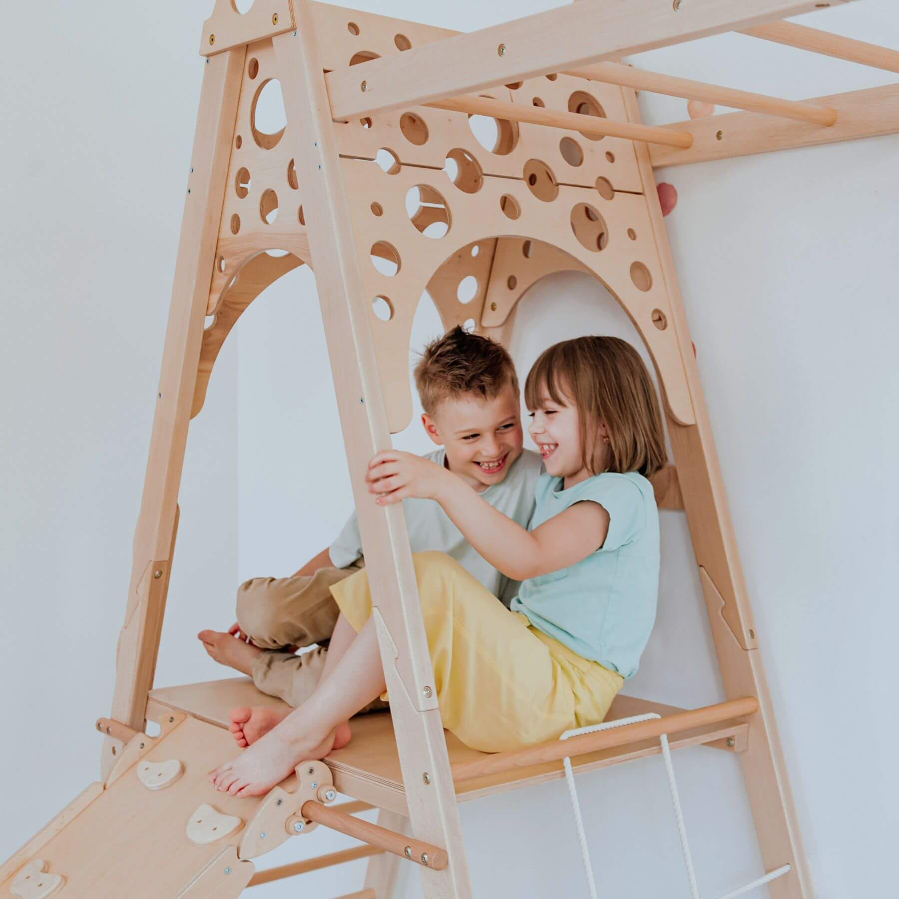 Two children playing inside Wood and Hearts Wooden Playground