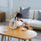 Girl Feeding Teddy Bear next to PlanToys Activity Clock