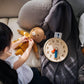 Girl Playing Teddy Bear next to PlanToys Activity Clock