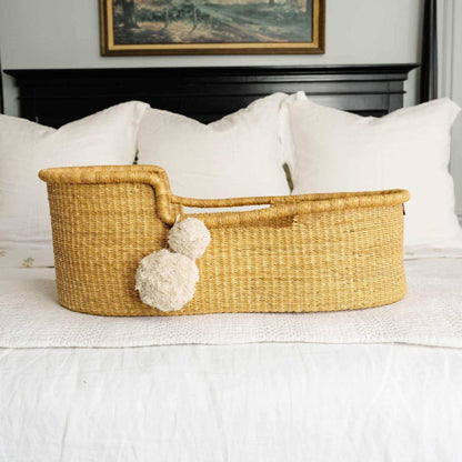 Plum+Sparrow Inset Handle Moses Basket on a bed