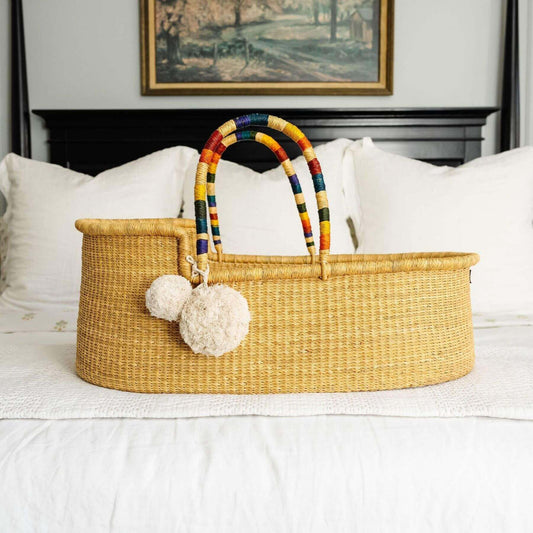 Plum+Sparrow African Moses Basket Rainbow Vegan Handle on a bed