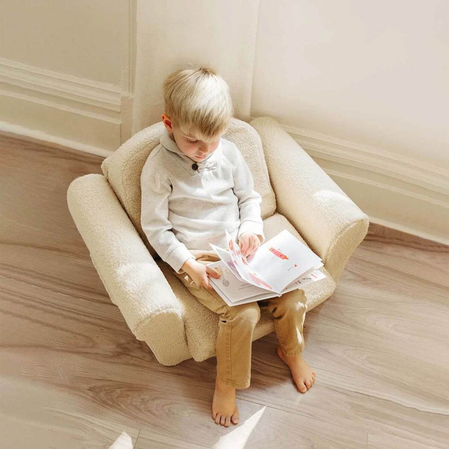 Boy Reading on Tiny Land® Afternoon Couch —— Cream Kids Chair