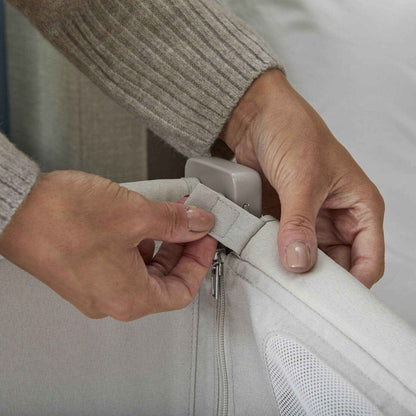 Person adjusting a zipper on Shnuggle Air Lite Bedside Crib