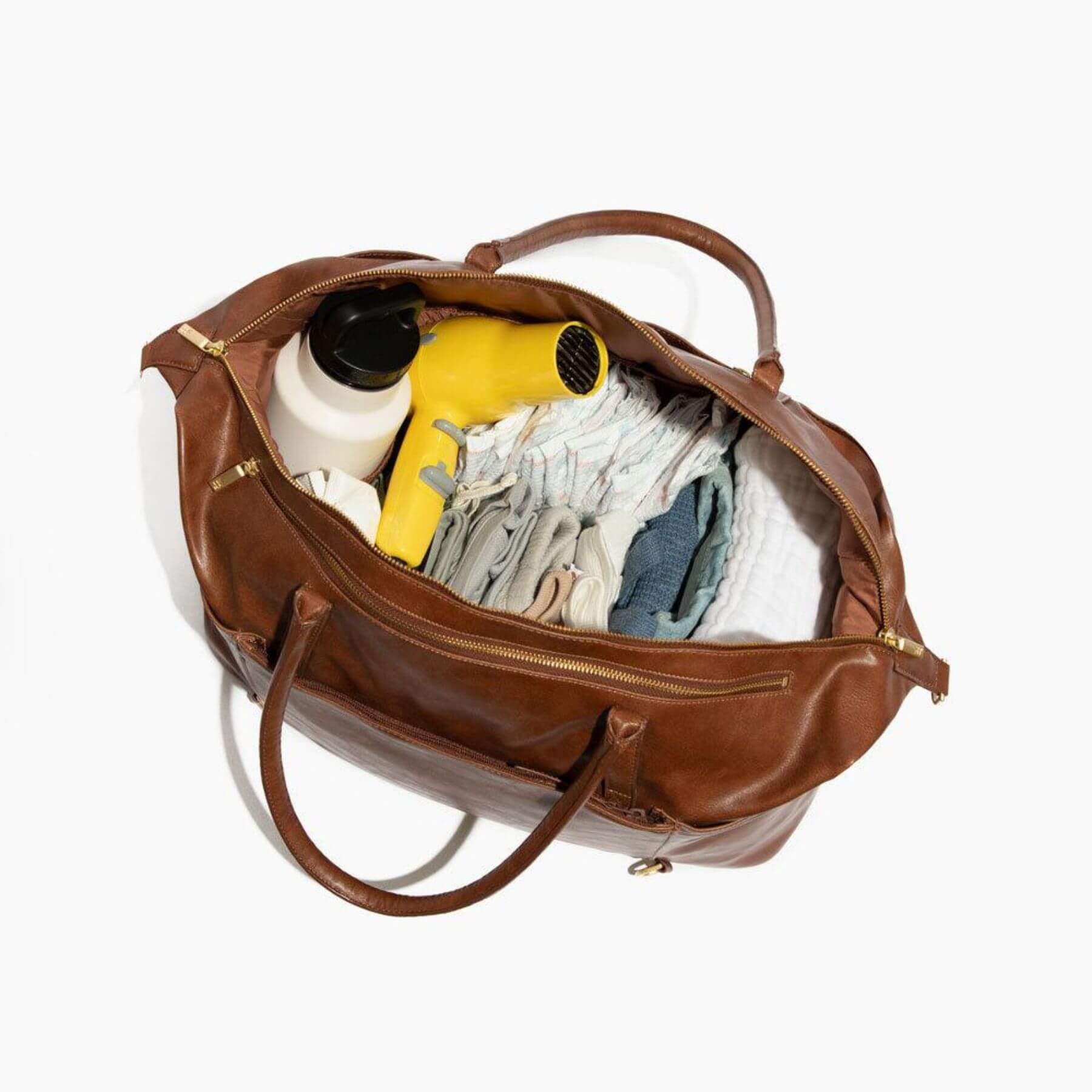Freshly Picked Amber Minimal Weekender with clothes and a yellow hair dryer