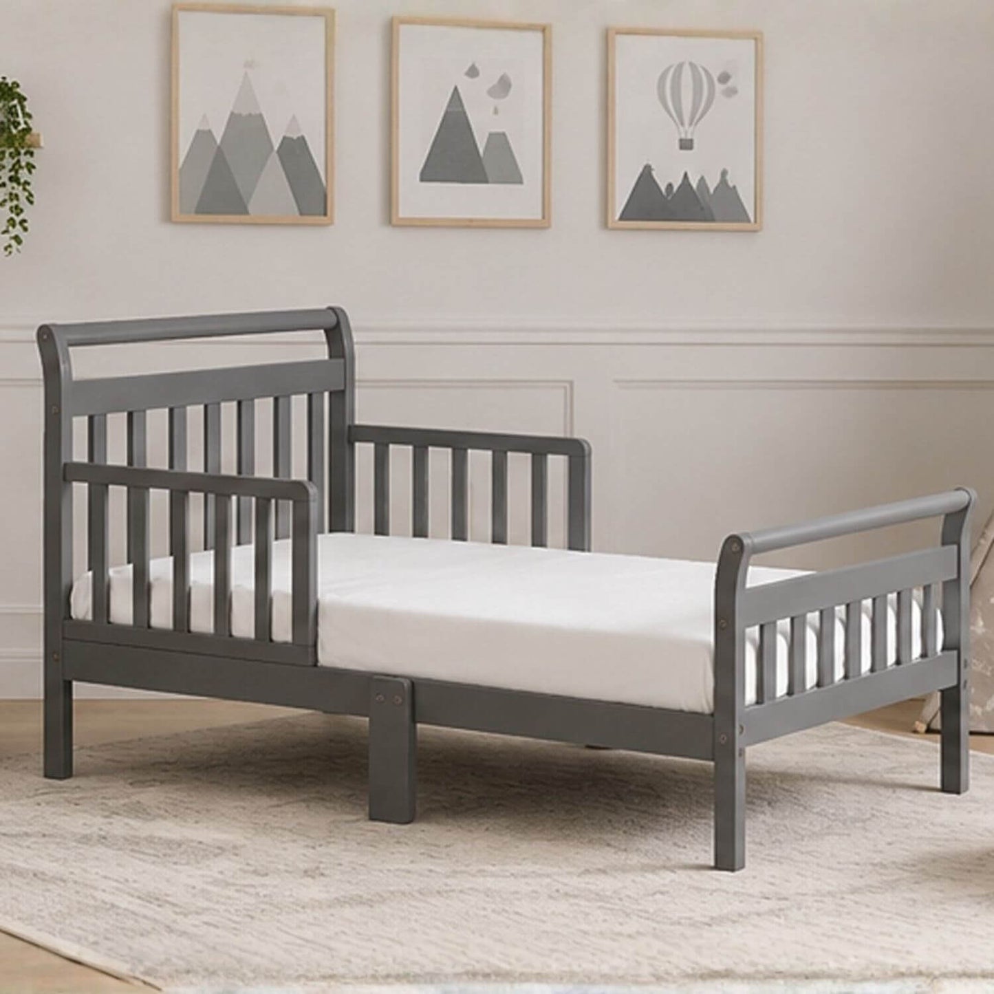 Anna Toddler Bed Grey in a room with framed pictures on the wall.