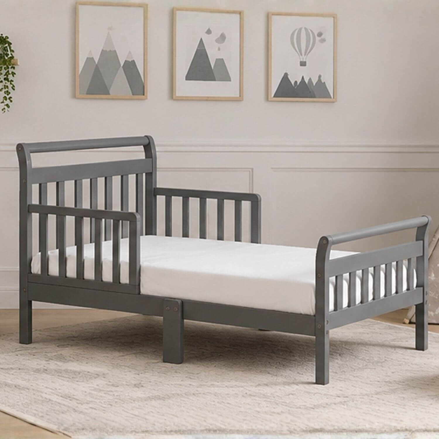 Anna Toddler Bed Grey in a room with framed pictures on the wall.