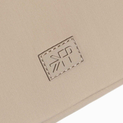 Close-up of a beige fabric surface with a logo patch.