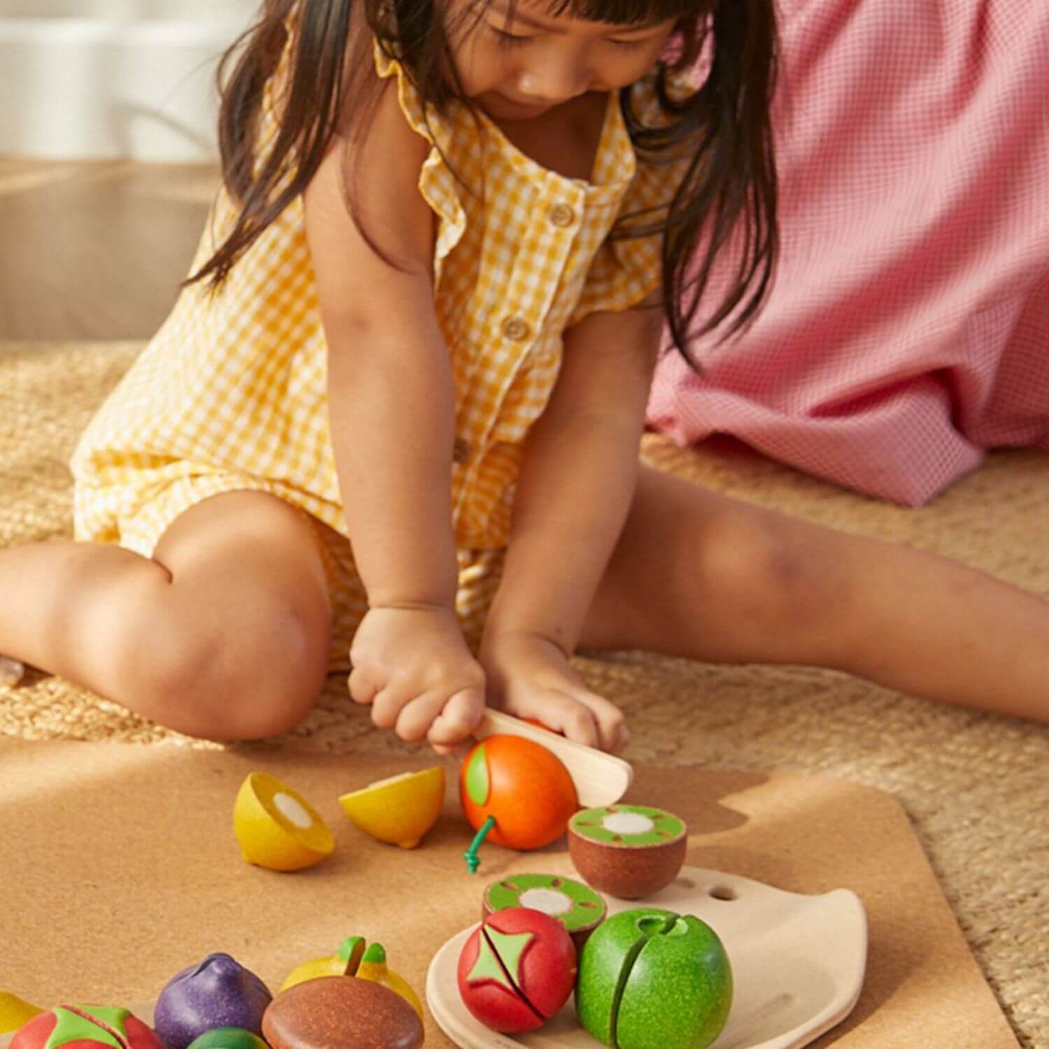 Girl Playing PlanToys Assorted Fruit Set