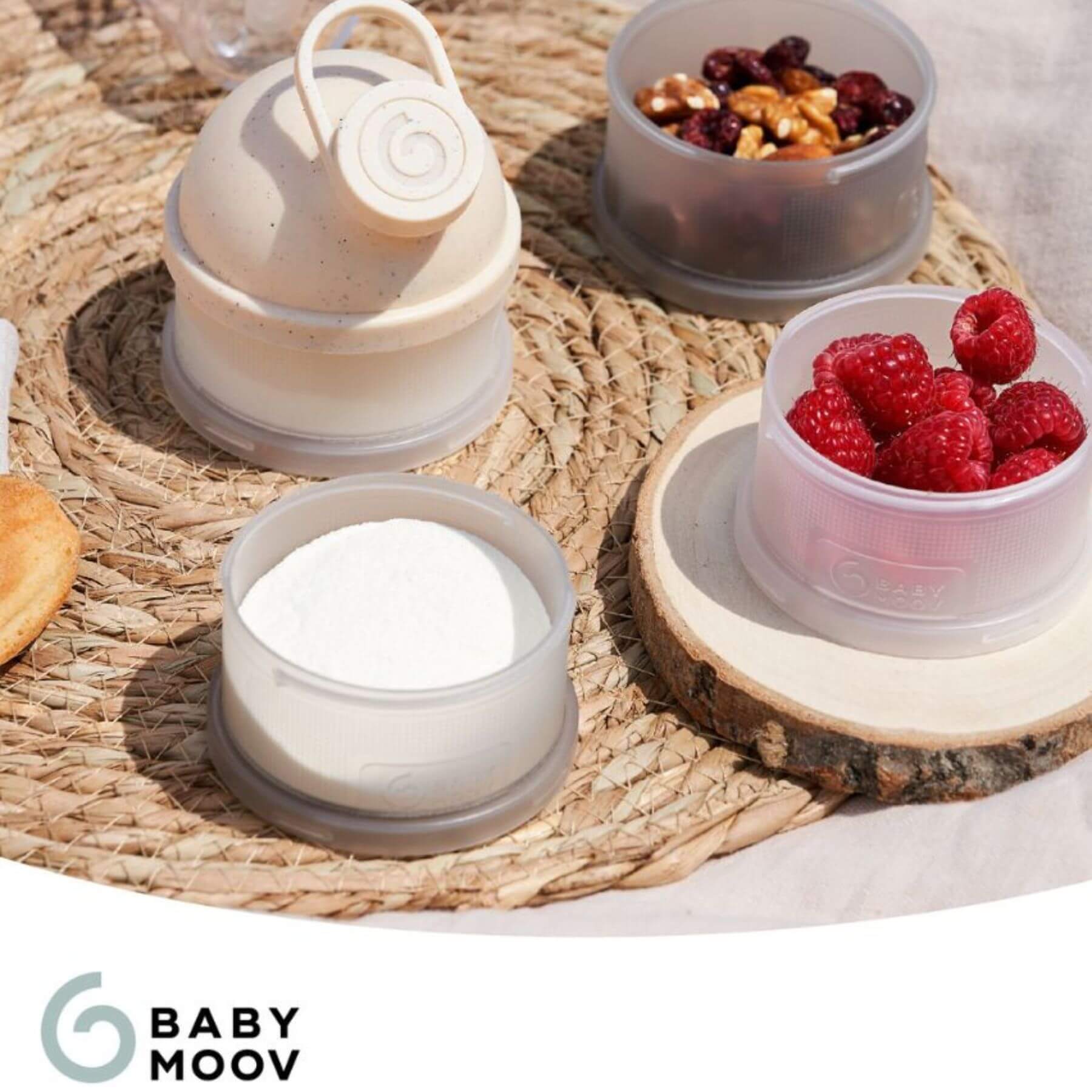 Baby Moov containers with snacks on a woven mat