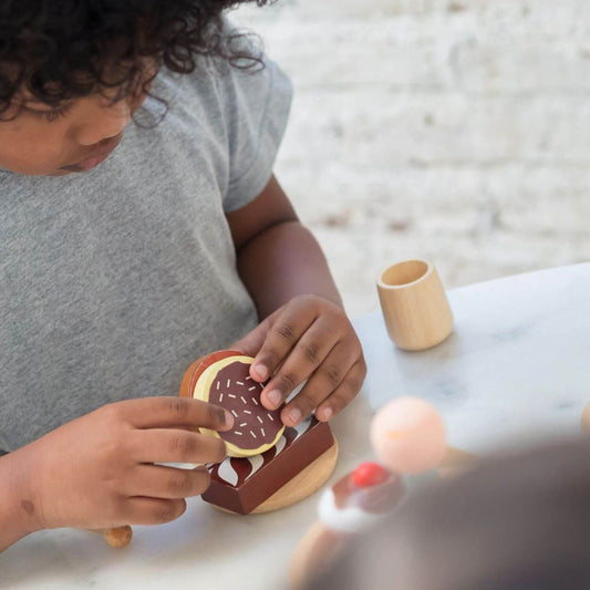 Boy Playing PlanToys Bakery Stand Set