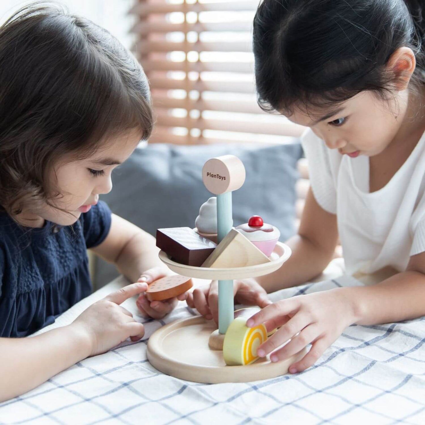 Girls Playing PlanToys Bakery Stand Set