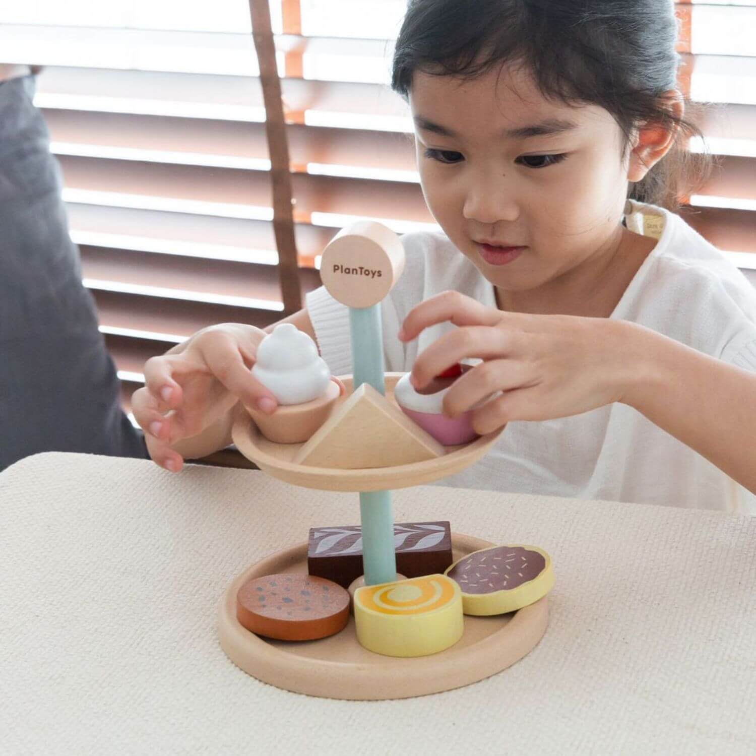 Girl Playing PlanToys Bakery Stand Set