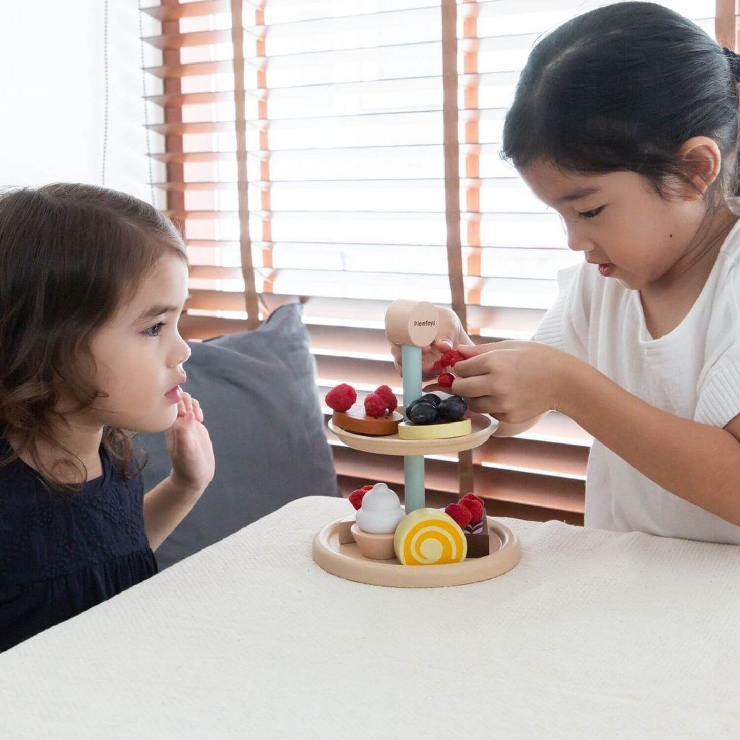 Girls Playing PlanToys Bakery Stand Set