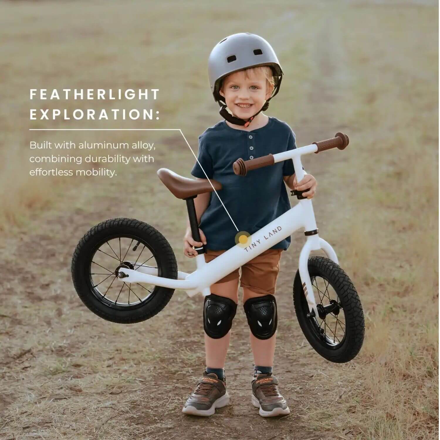 Boy Lifting Tiny Land® Balance Bike - Milky White