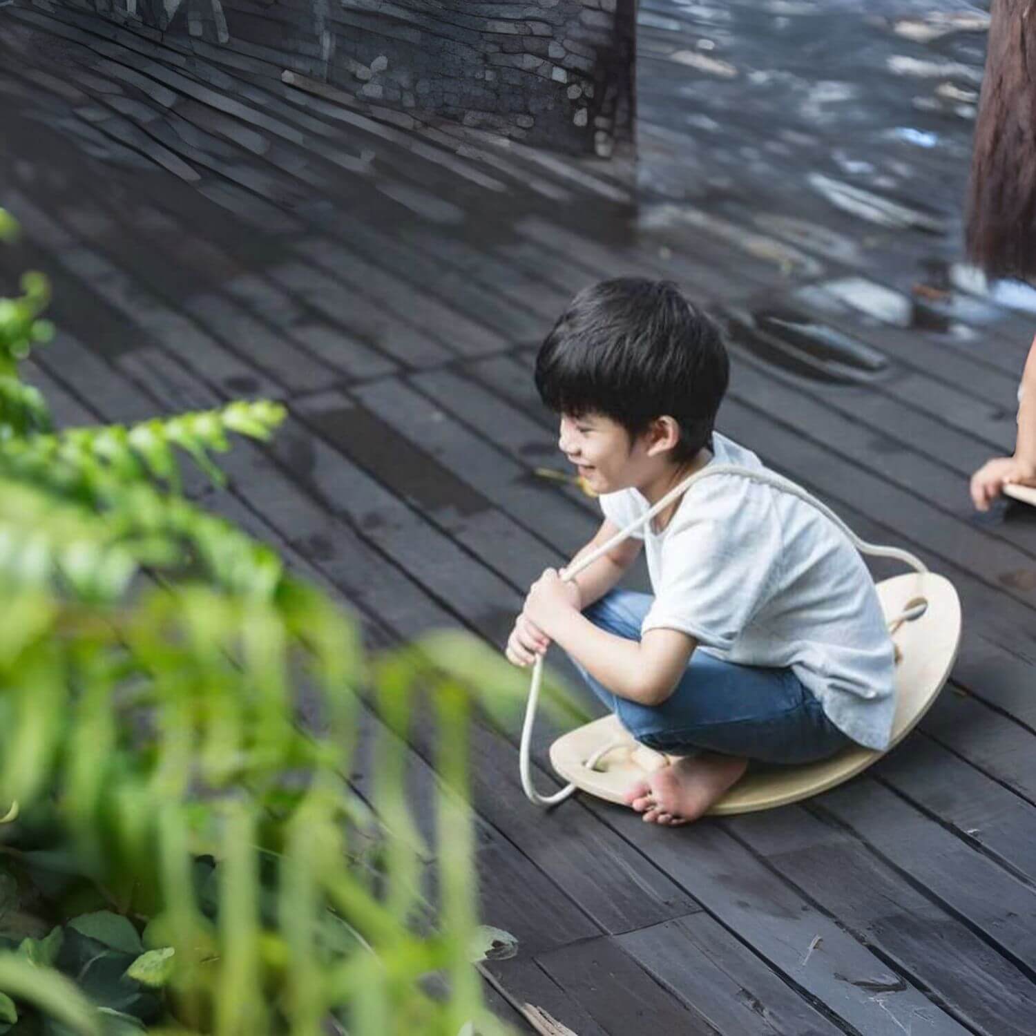 Boy Sitting on PlanToys Balance Board