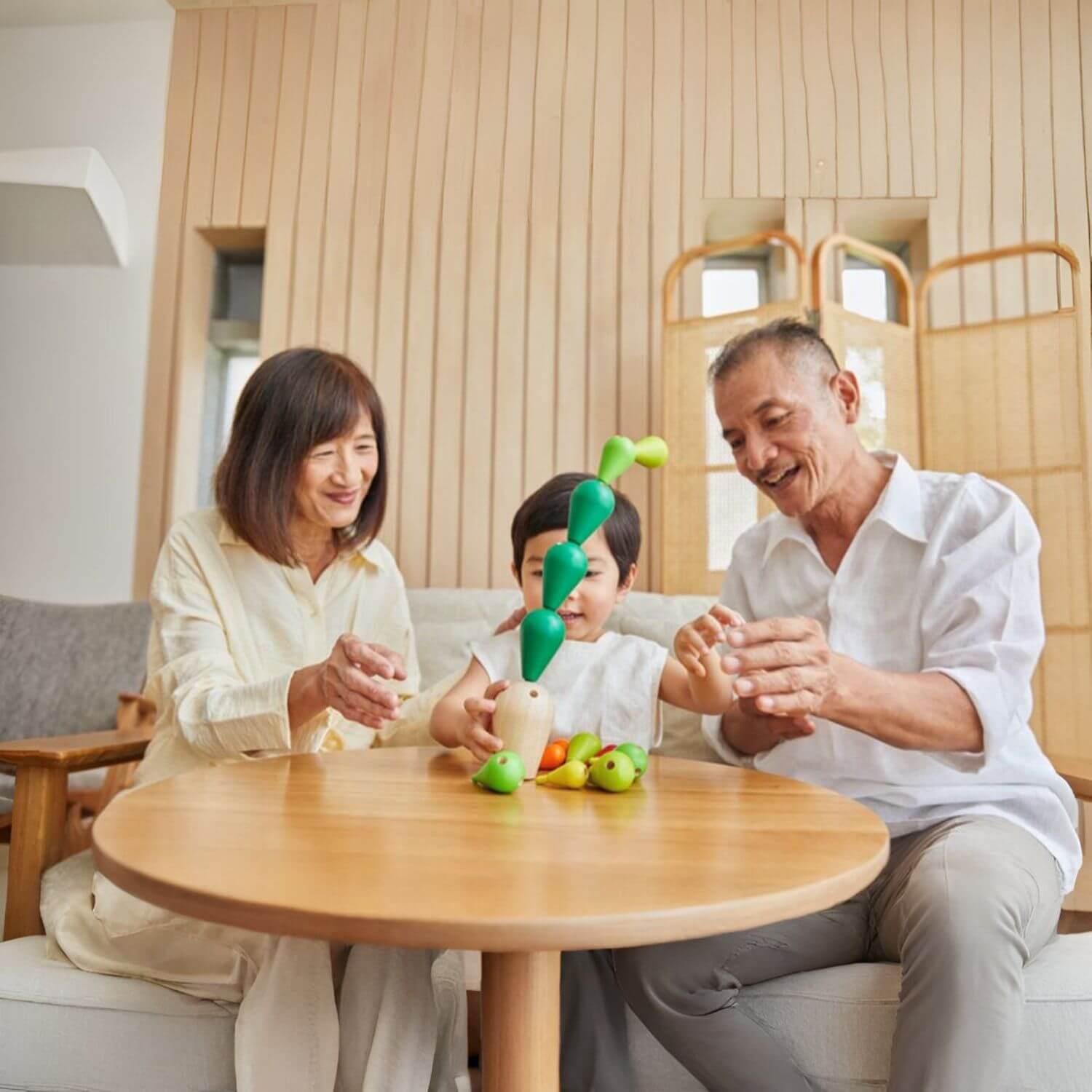 Parents and Kid Playing PlanToys Balancing Cactus