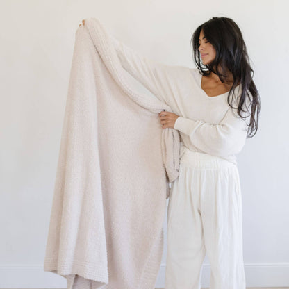 Woman holding Saranoni Bamboni® Throw Blanket against a white background