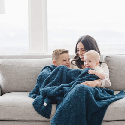 Woman and two children on a couch with Saranoni Bamboni® Throw Blanket