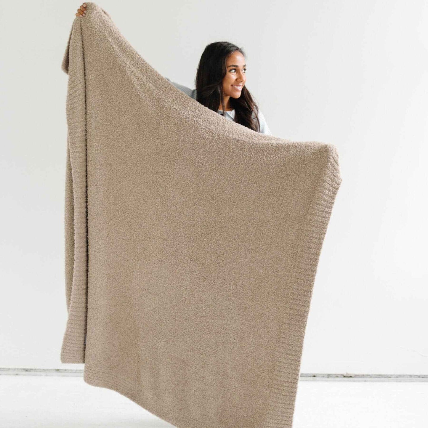Woman holding Saranoni Bamboni® Throw Blanket against a white background