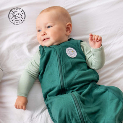 Baby in Bamboo Classic Sleep Sack - Forest Green, lying on bed