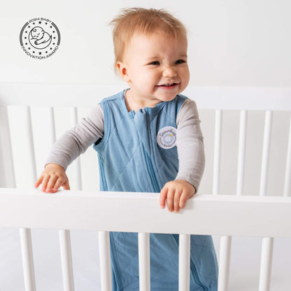 Baby standing in crib, wearing Bamboo Classic Sleep Sack - Ocean Blue