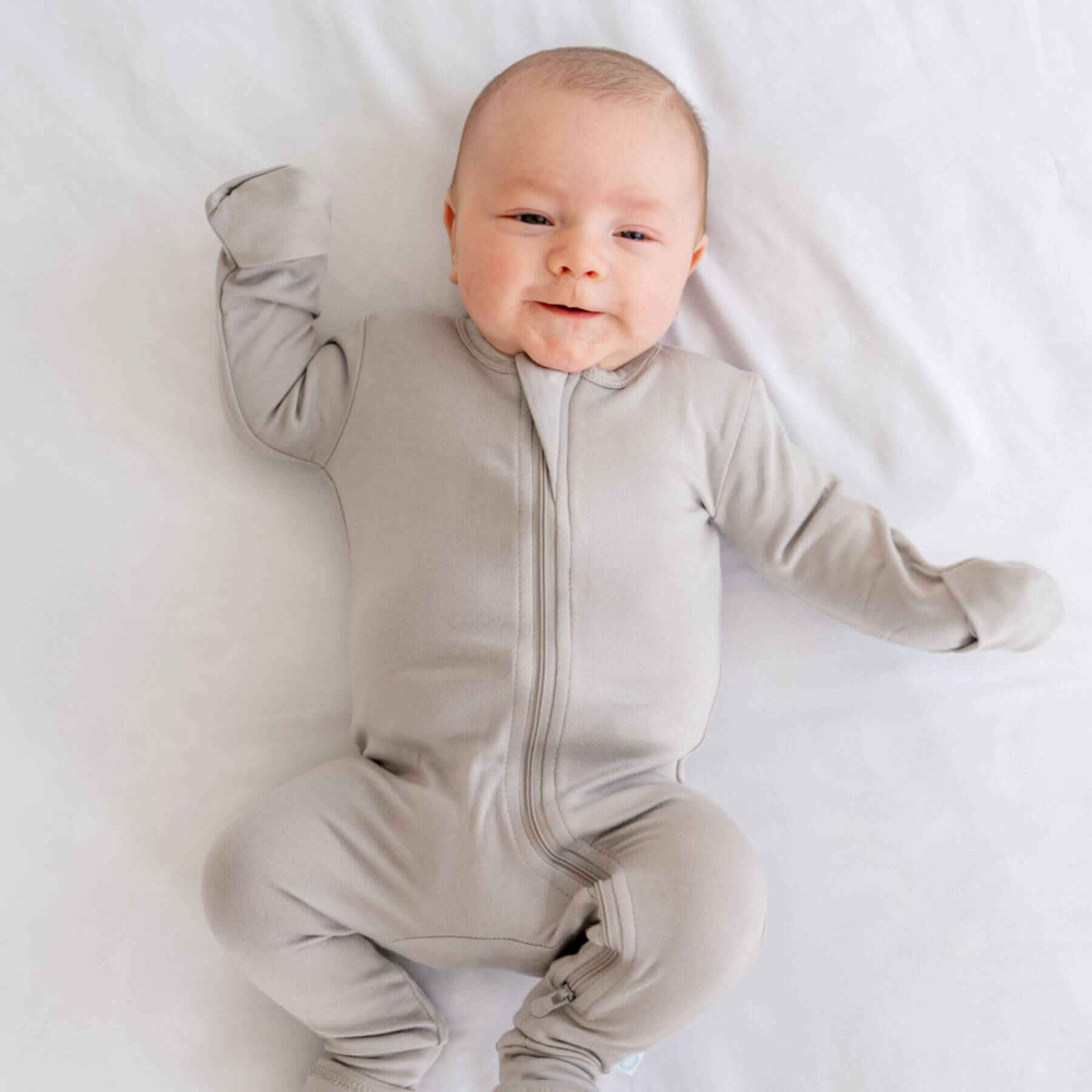 Baby wearing Dreamland Baby Bamboo Pajamas w/ DreamCuffs® - Grey on a white background