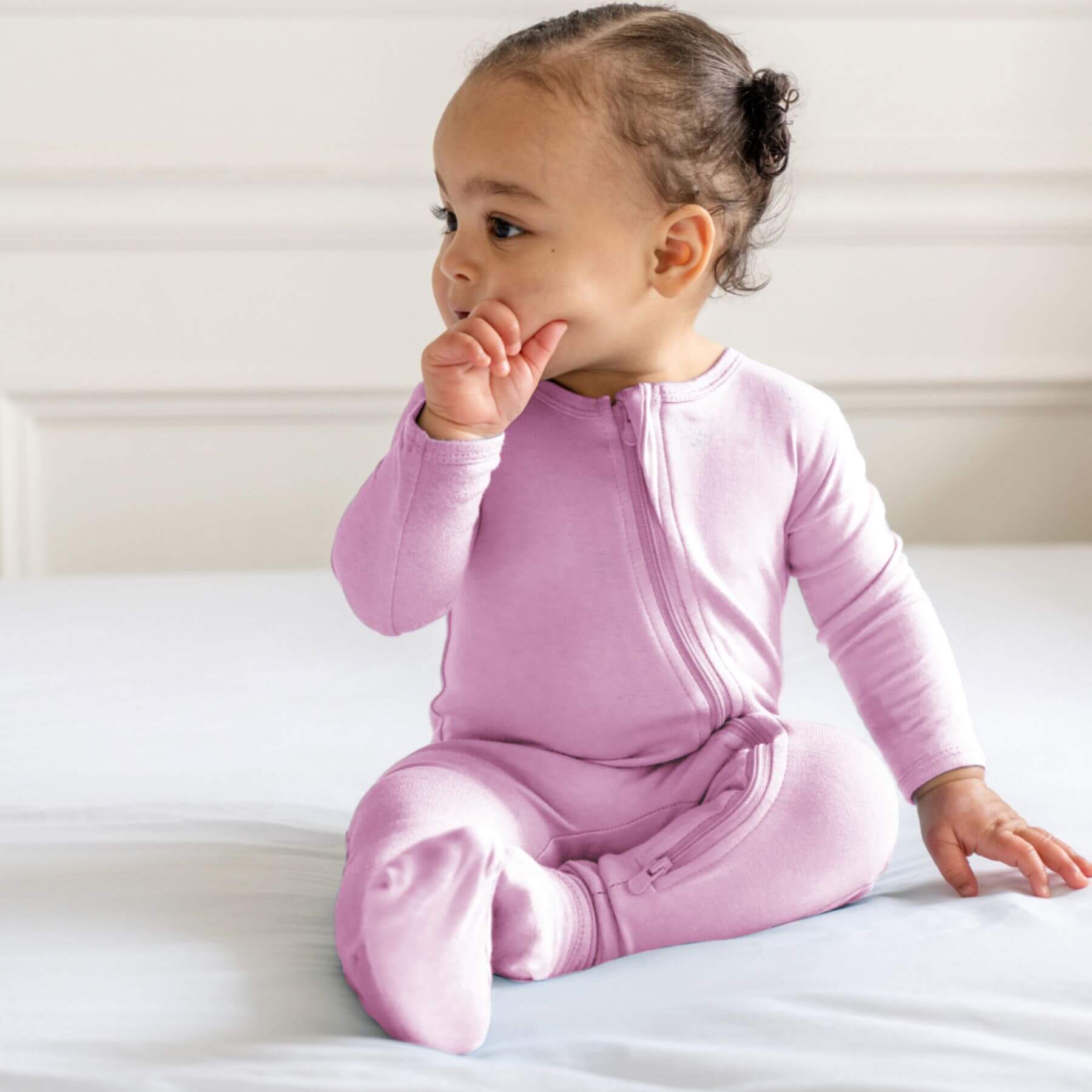 Baby in Dreamland Baby Bamboo Pajamas w/ DreamCuffs® - Mauve sitting on a white surface