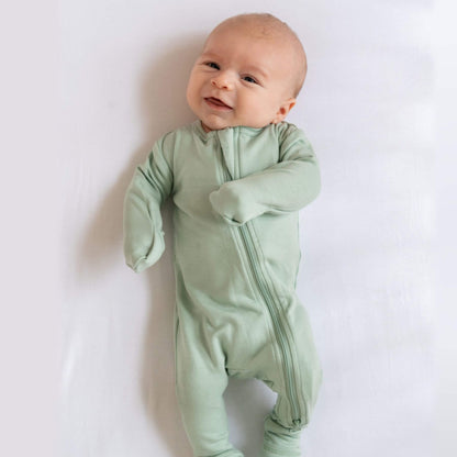 Baby wearing Dreamland Baby Bamboo Pajamas w/ DreamCuffs® - Sage on a white background