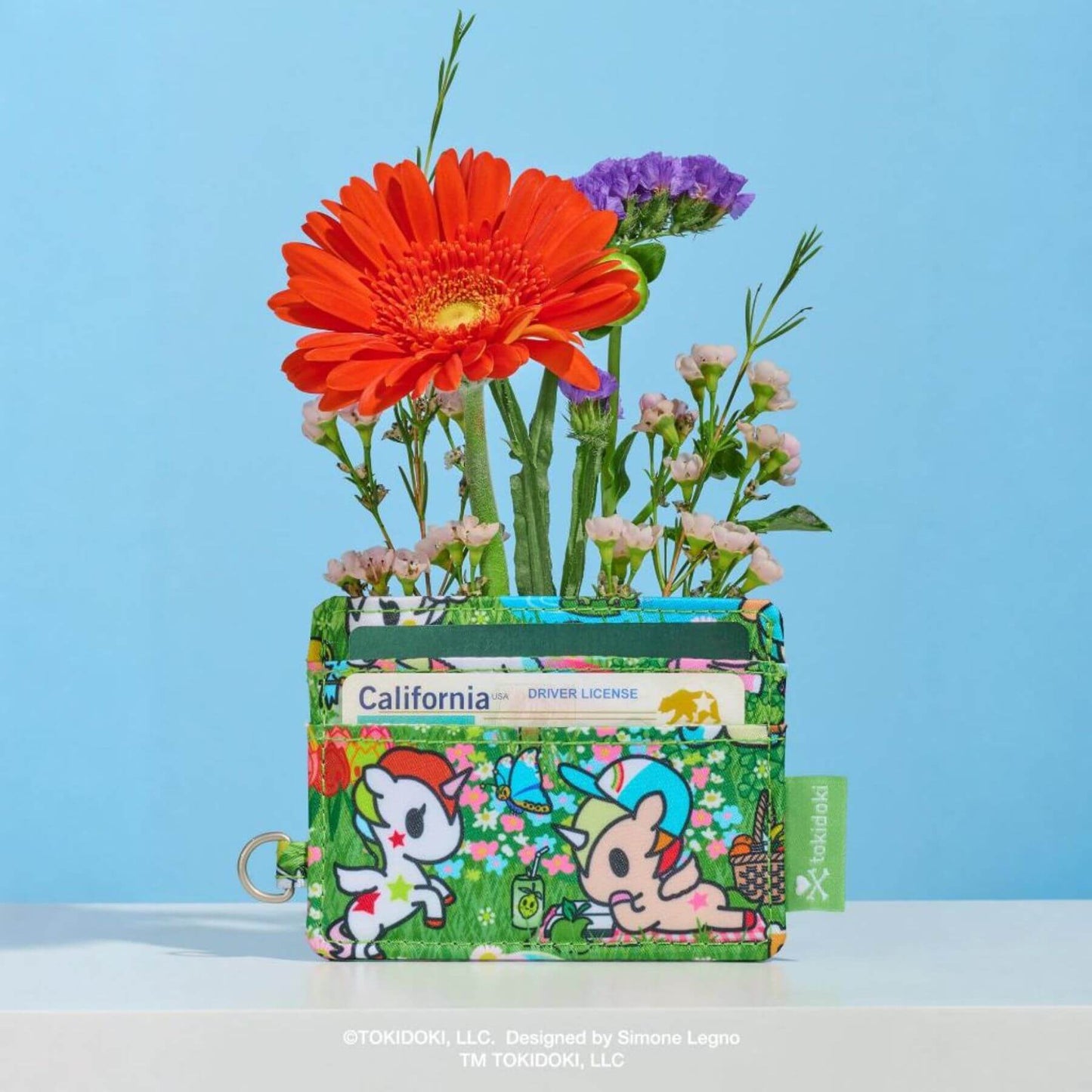 Floral arrangement in a small pouch with cartoon characters on a blue background