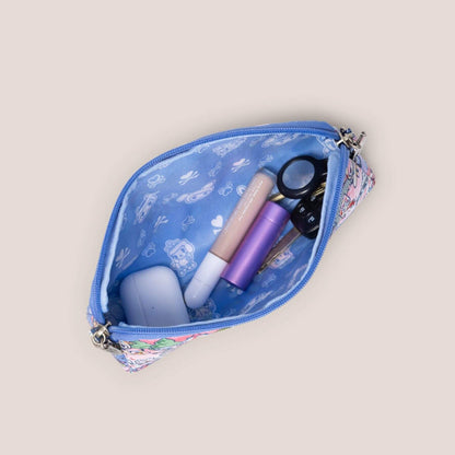 Small blue pouch with cosmetic items on a beige background