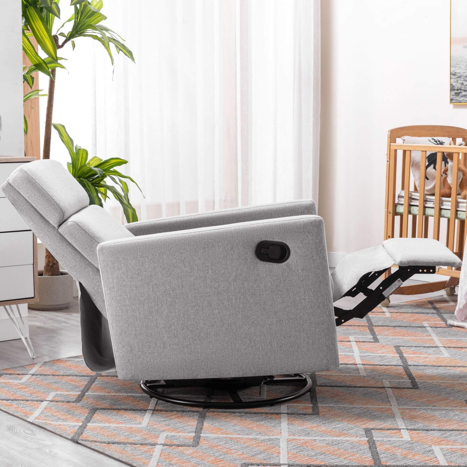 Gray recliner chair in a living room setting with plants and a rug.