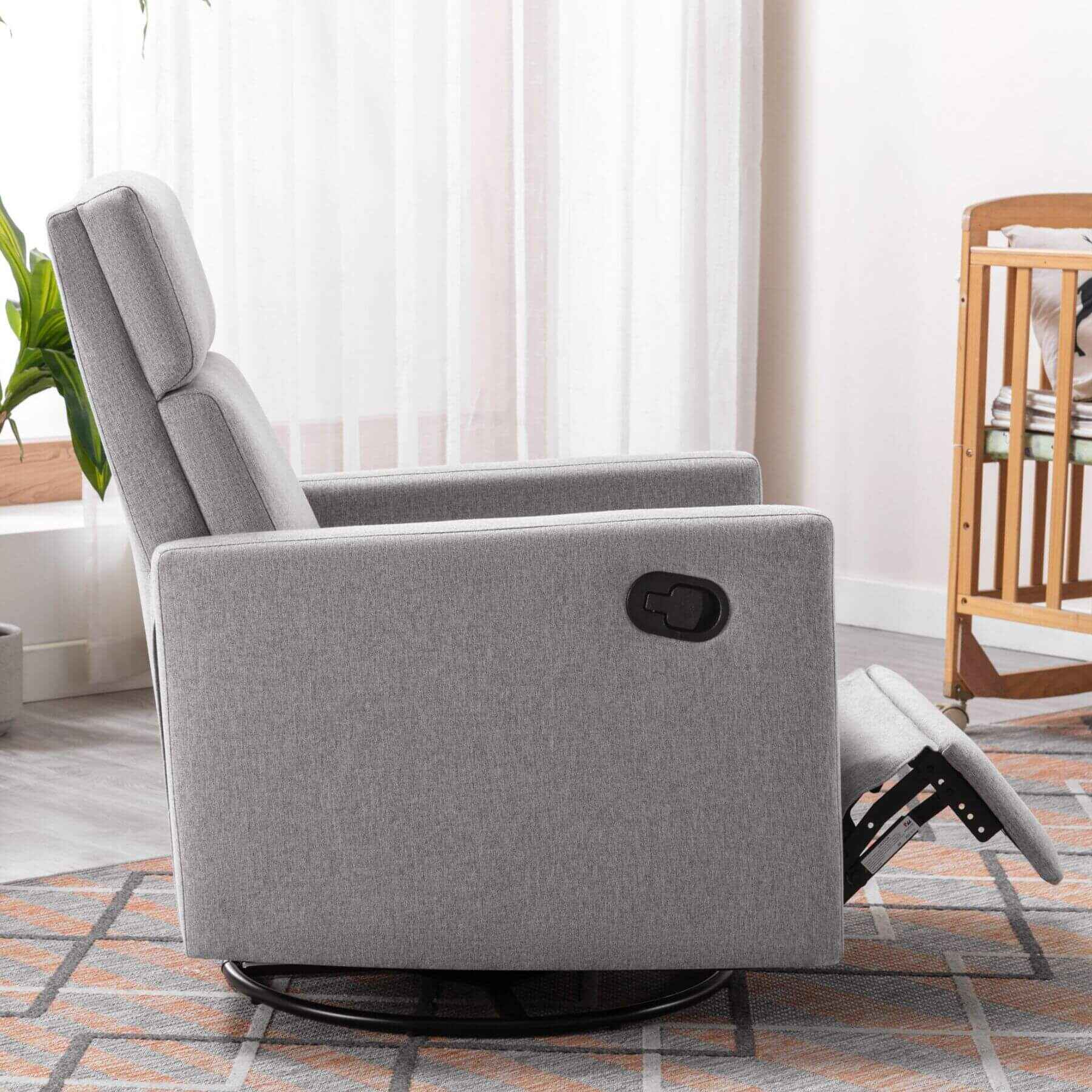 Gray recliner chair in a living room setting with a plant and wooden chair in the background.