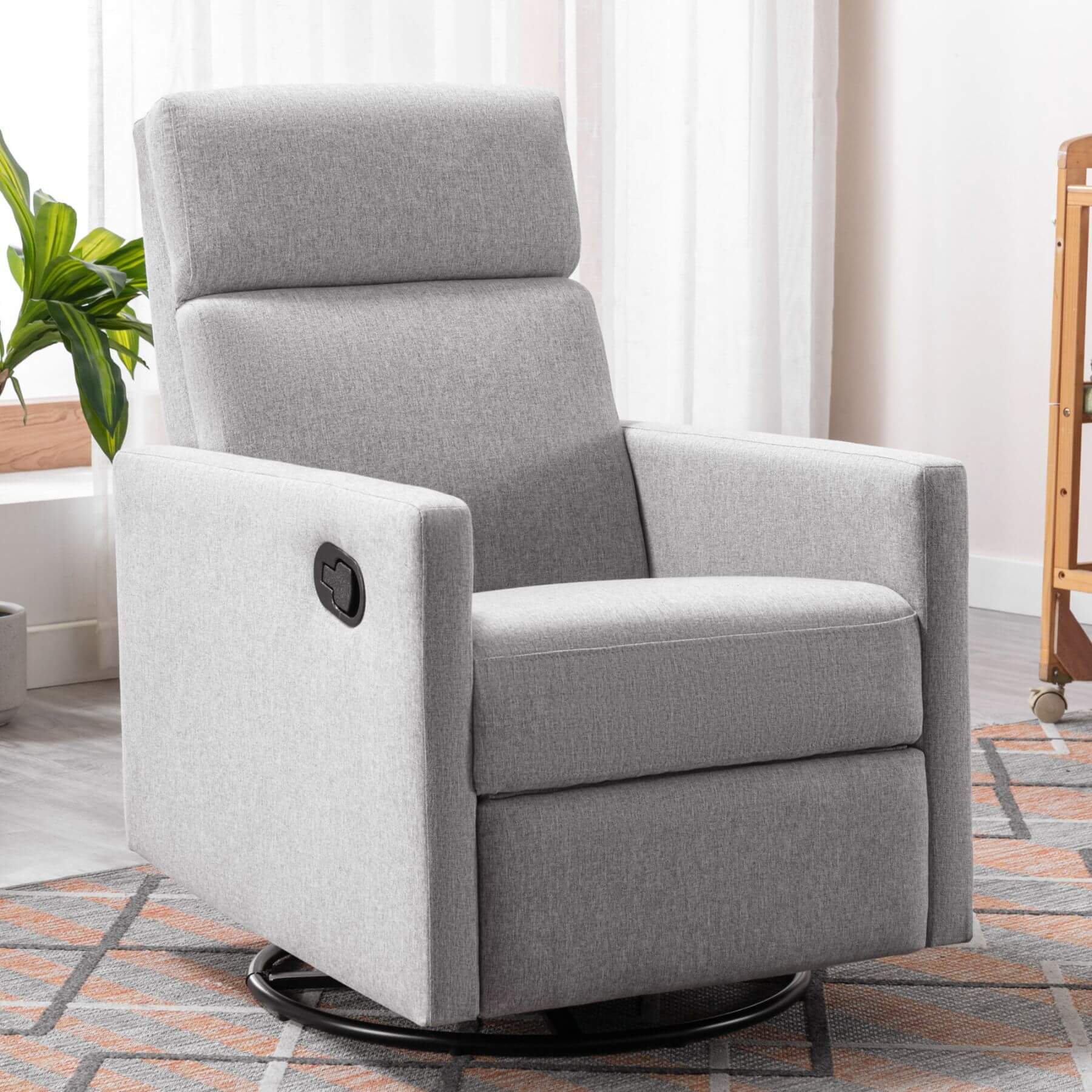 Gray recliner chair in a living room setting with a plant and rug.