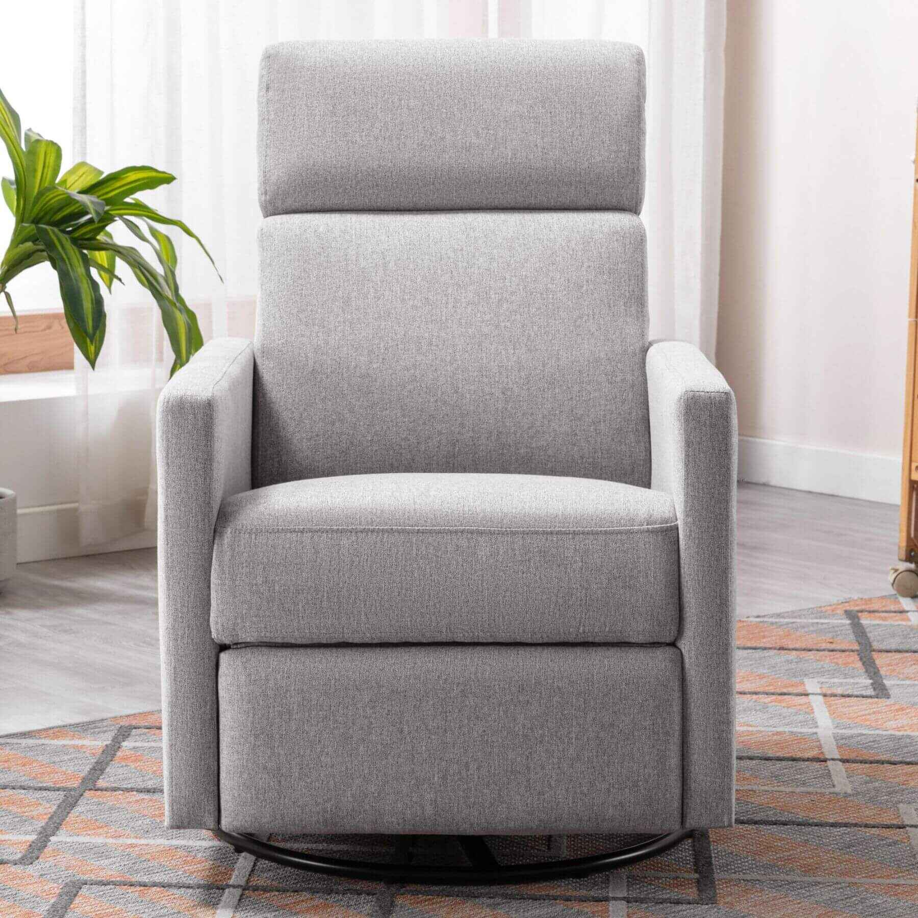 Gray recliner chair in a room with a plant and curtains