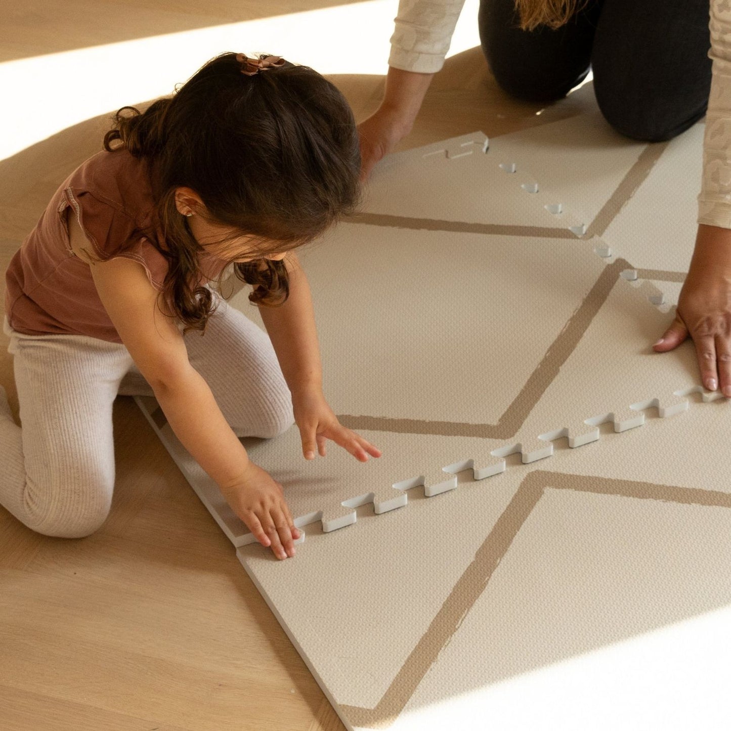 Kids setting up Eeveve Beni Autumn Gold Play Mat