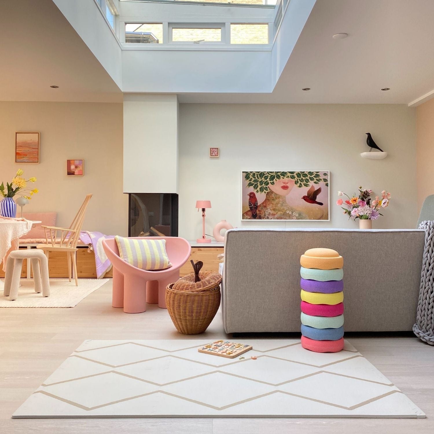 Modern living room with colorful stools, a sofa, and decorative elements.