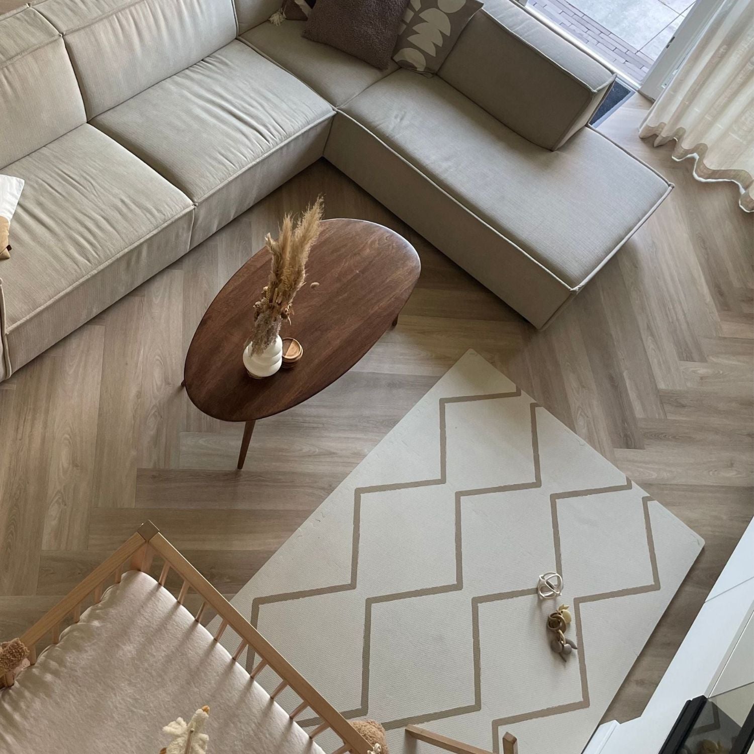 Living room with beige sectional sofa, wooden coffee table, and Eeveve Beni Autumn Gold Play Mat