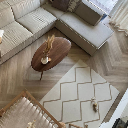 Living room with beige sectional sofa, wooden coffee table, and Eeveve Beni Autumn Gold Play Mat