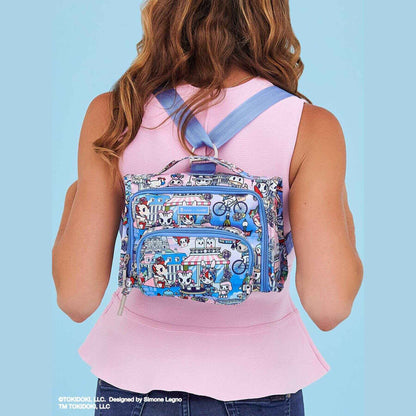 Person wearing tokidoki The Bestie Small Messenger Handbag - C'est la vie à Paris on a light blue background
