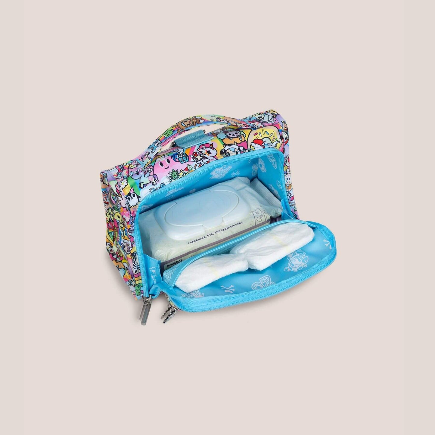 tokidoki The Bestie Small Messenger Handbag with baby wipes and diapers on a beige background