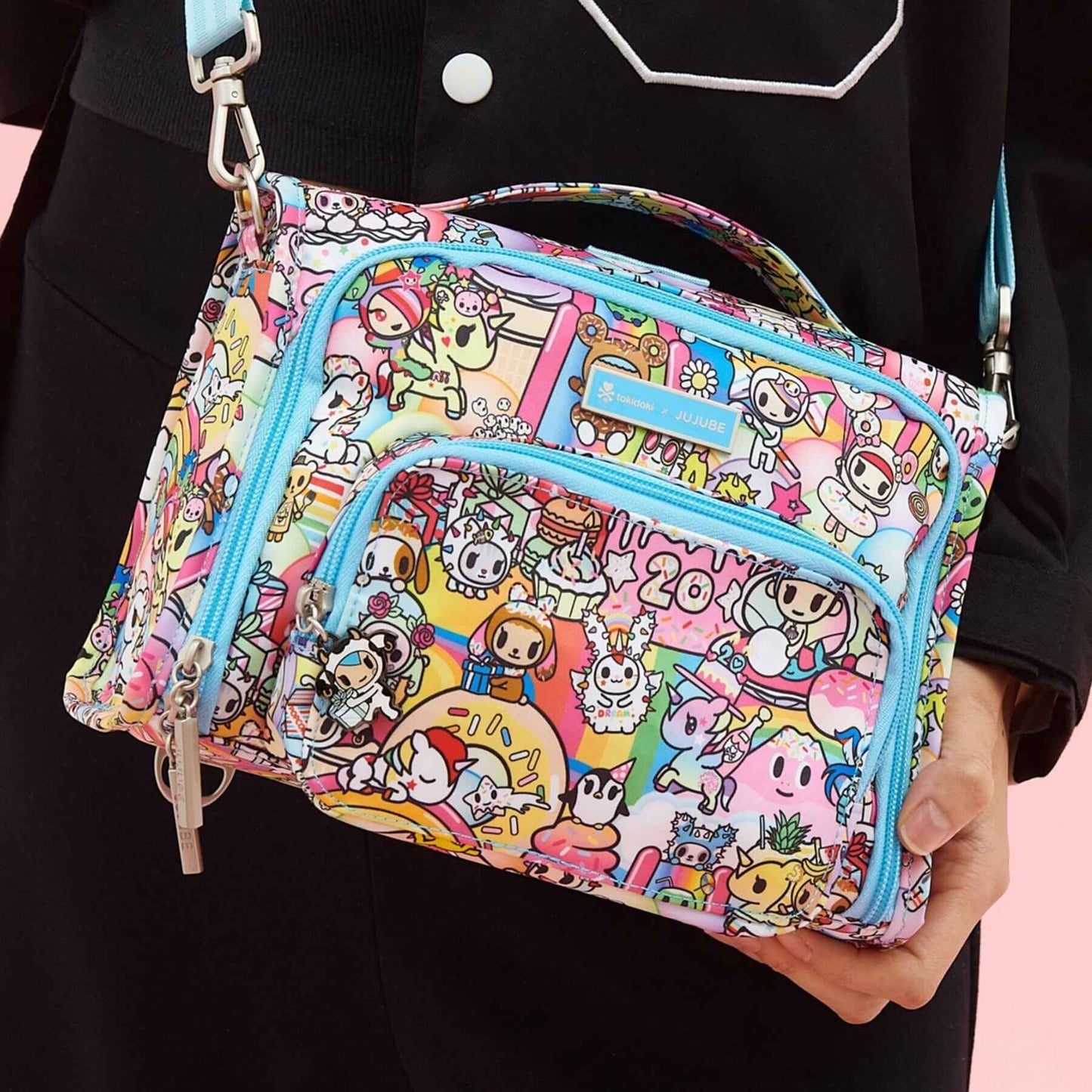 tokidoki The Bestie Small Messenger Handbag held by a person against a black background.