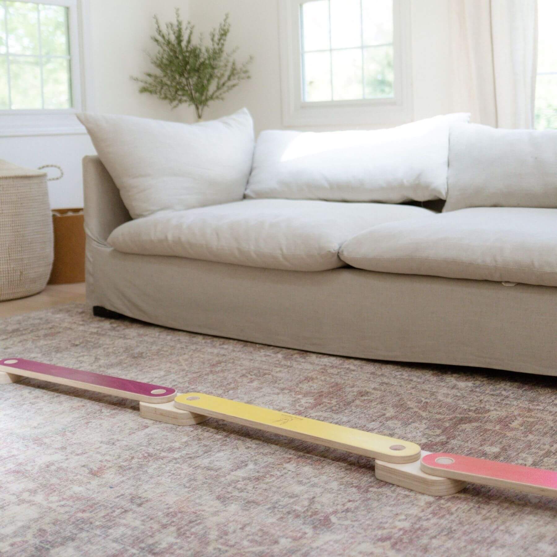 Bunny Hopkins Balance Beam on a carpeted floor with a beige sofa in the background