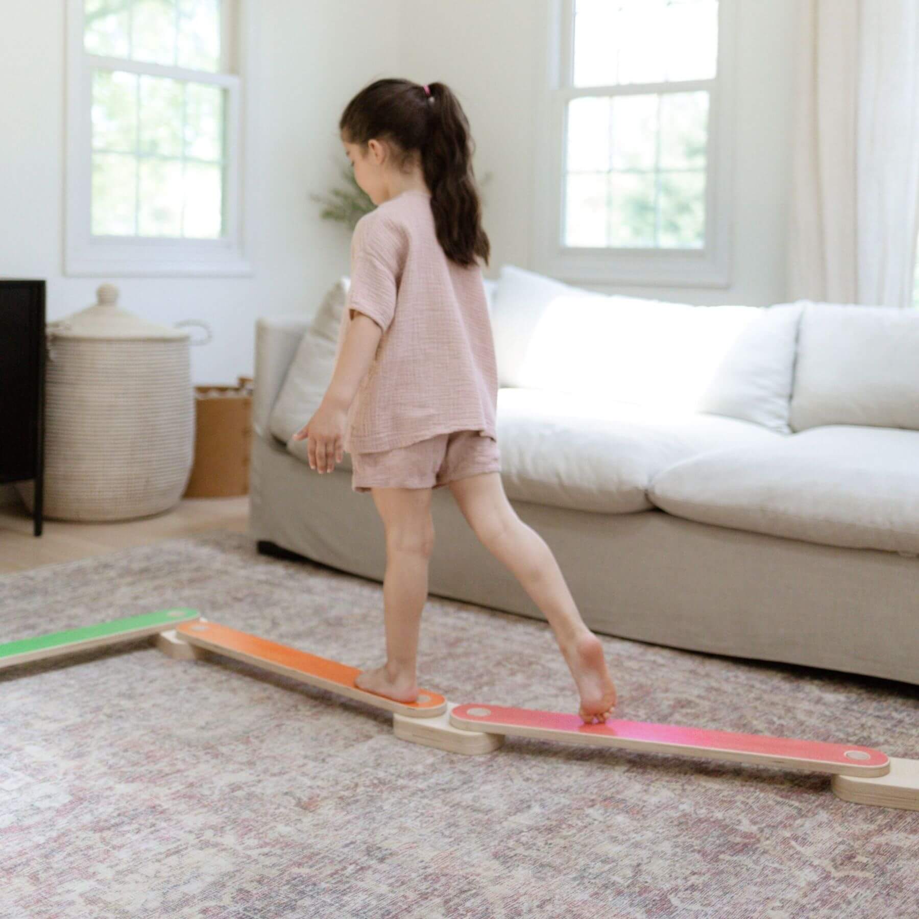 Child standing on Bunny Hopkins Balance Beam in a living room