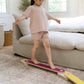 Child balancing on Bunny Hopkins Balance Beam in a living room.