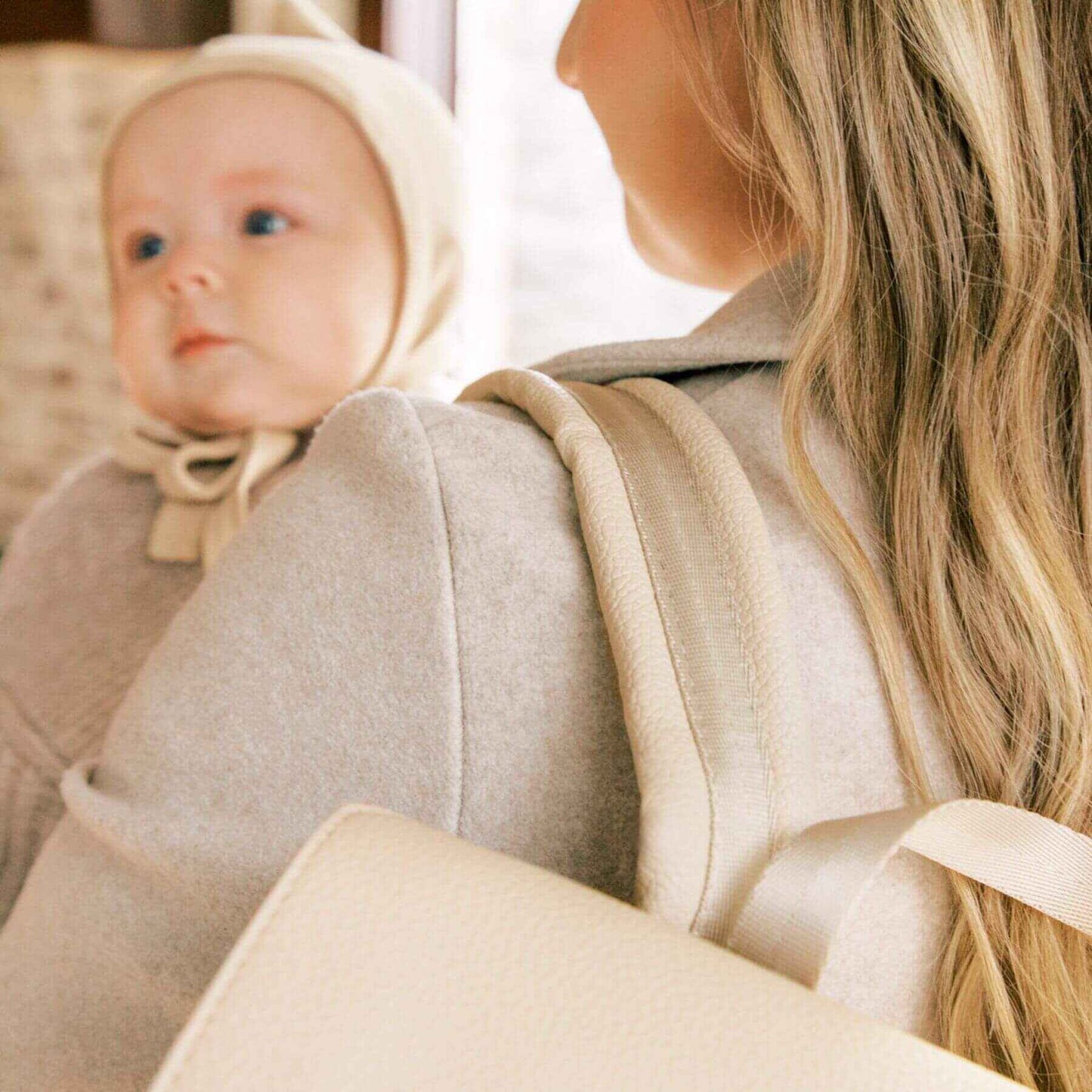Woman holding a baby wearing Freshly Picked Birch Classic Diaper Bag II