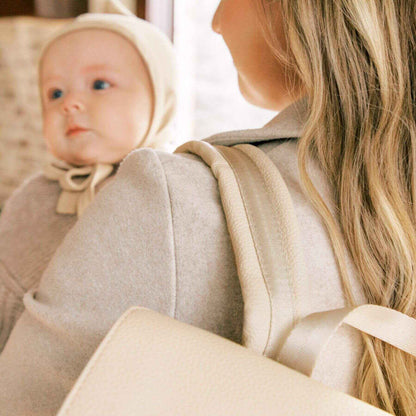 Woman holding a baby wearing Freshly Picked Birch Classic Diaper Bag II