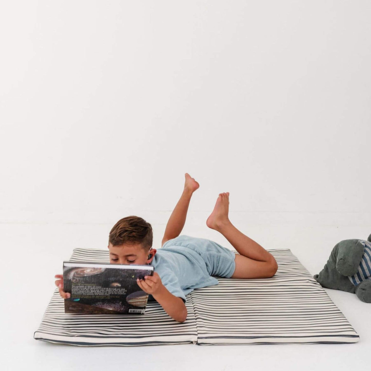 Child lying on Toki Kids Bold Stripe Vegan Leather Mat