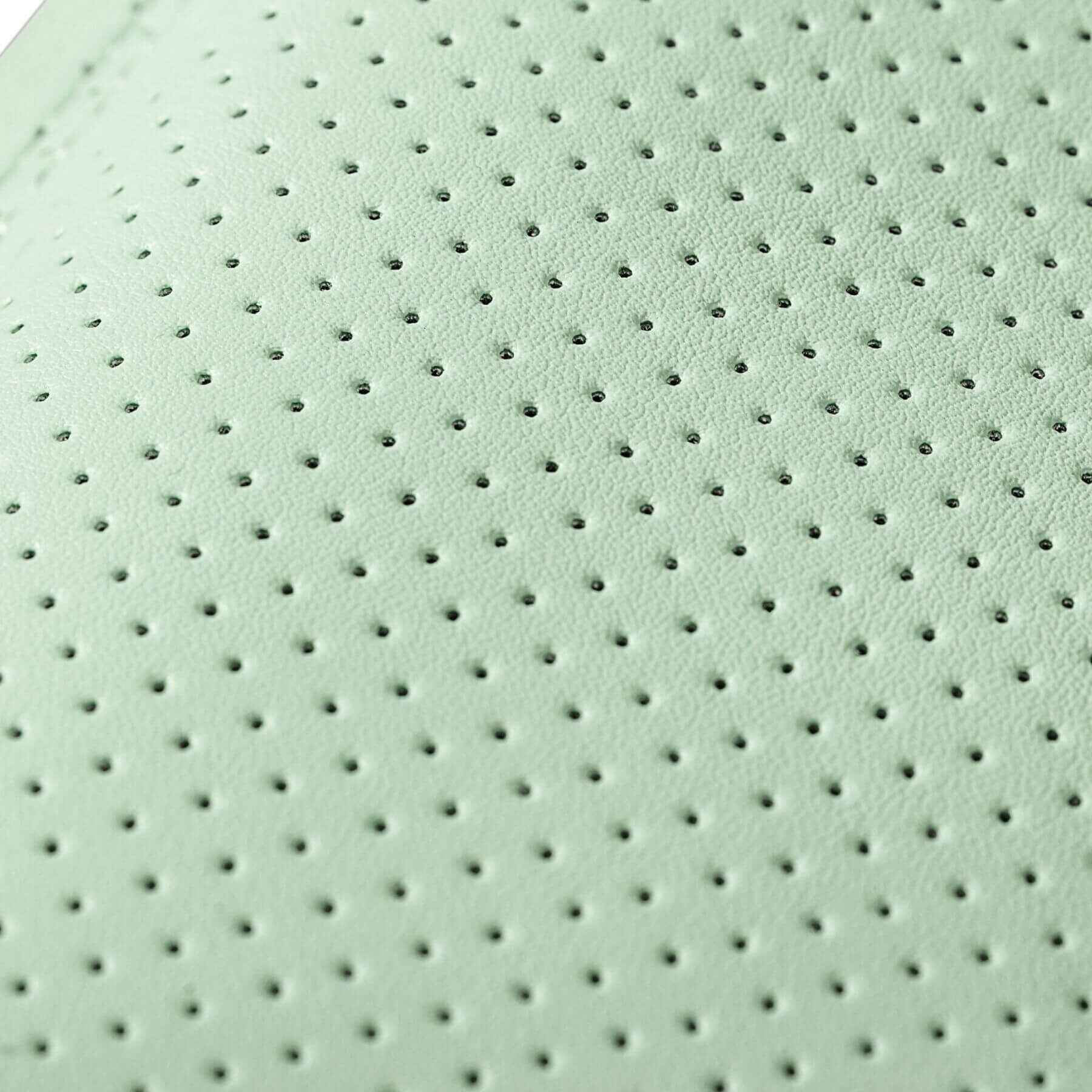 Close-up of a light green fabric with a perforated pattern
