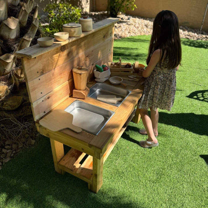Child playing with Bunny Hopkins Mud Kitchen on grass