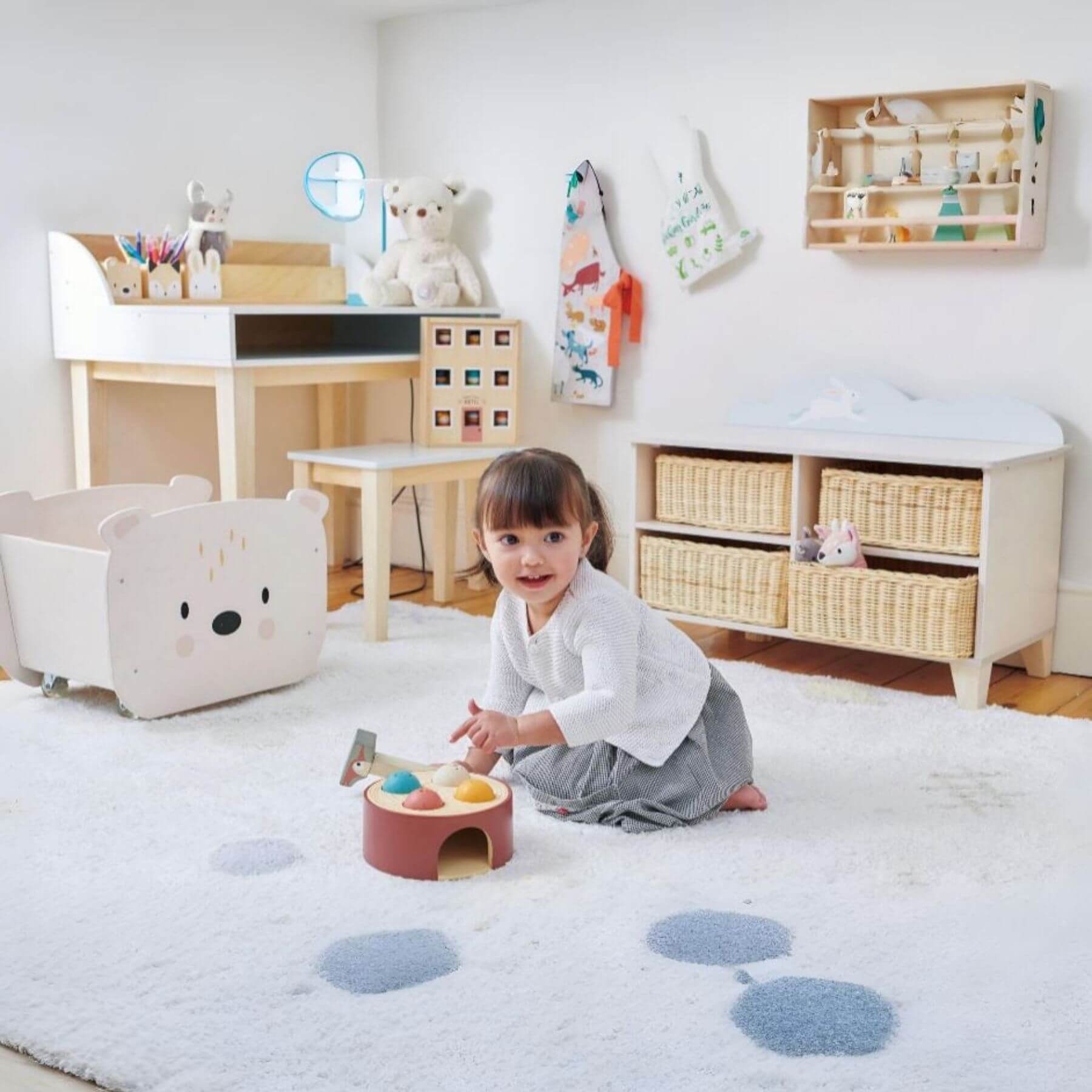 Child playing with a toy in a room with wooden furniture and toys.
